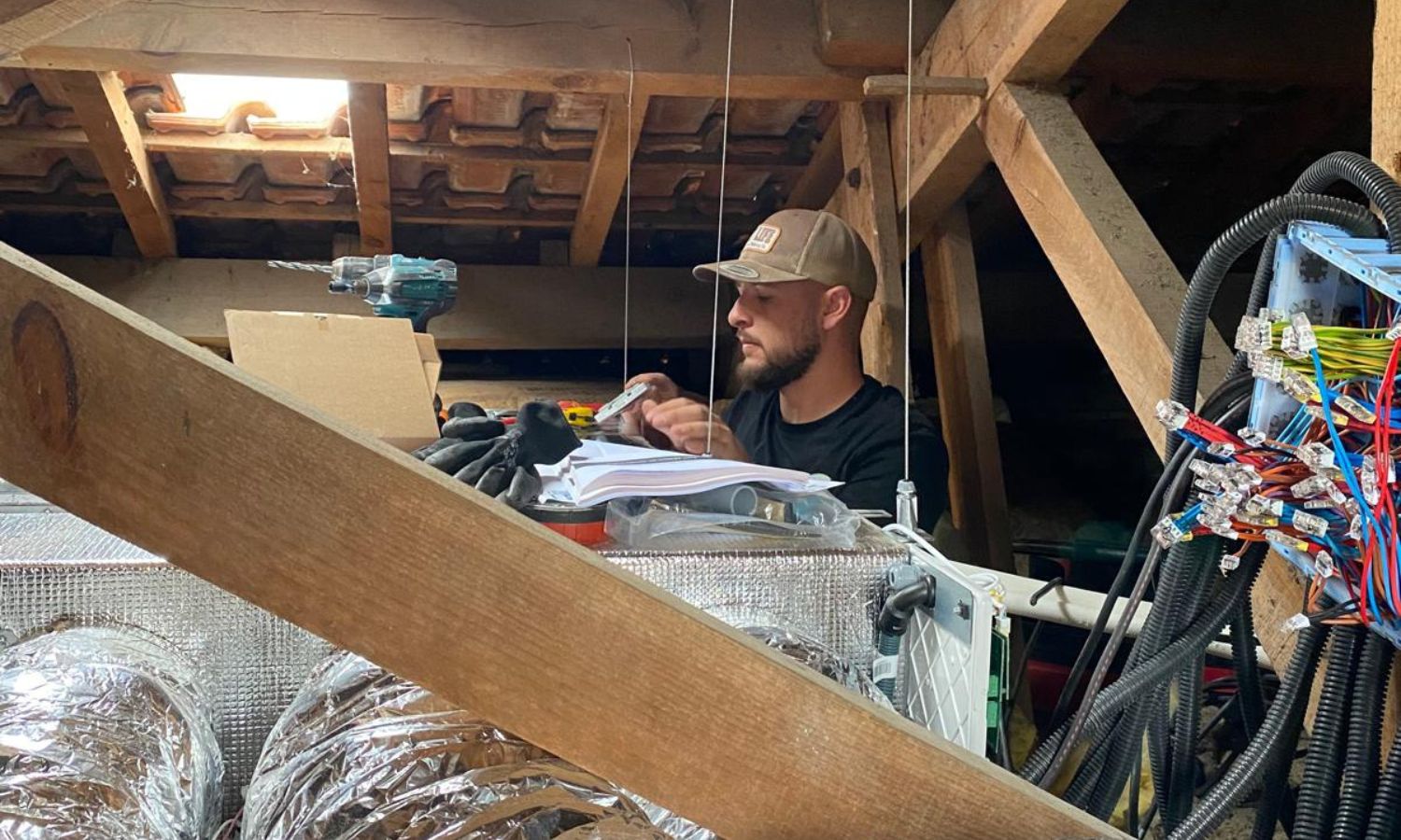 Ouvrier sur un chantier devant une unité intérieure d'un gainable